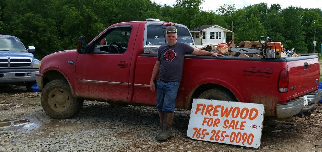 Firewood in truck with "Firewood for sale 765-265-0090" sign